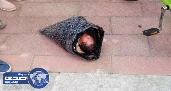 سيدة تلقي رضيعها أمام دار أيتام في كيس بلاستيك