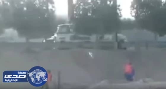 بالفيديو.. حاج يزيل آثار المطر عن صورة خادم الحرمين