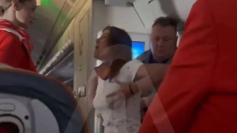راكبة تثير الفوضى في إحدى الرحلات الجوية وتهدد بفتح مخرج الطوارئ.. فيديو