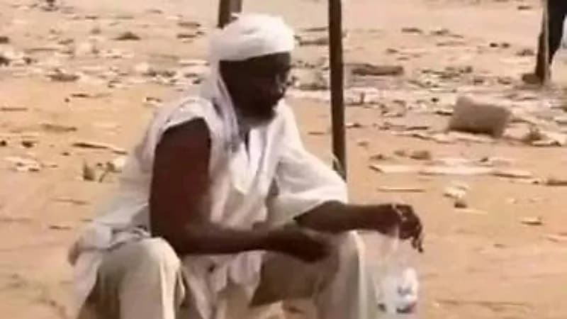 رجل يتوضأ للصلاة وسط اشتعال أعمال النهب في أشهر سوق بالخرطوم