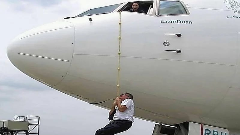 طيار يسخر من صورة آخر تدلى من الطائرة بحبال: تأخروا عليه الركاب قال اتمرجح شوي