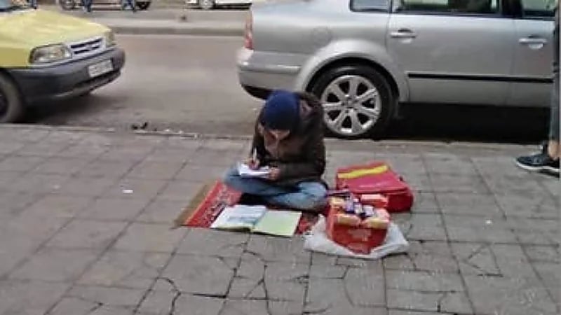 صورة لطفلة سورية تدرس أثناء بيعها الحلوى في الشارع