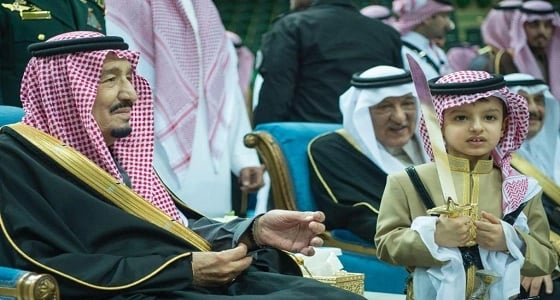 بالصور.. من الطفل الذي وقف بجانب الملك سلمان أثناء العرضة في الجنادرية؟