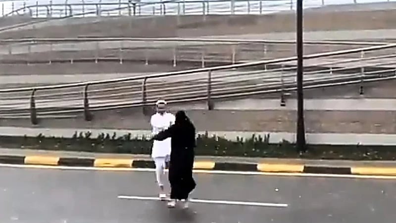 زوجان يوثقان لحظة رومانسية تحت المطر .. فيديو